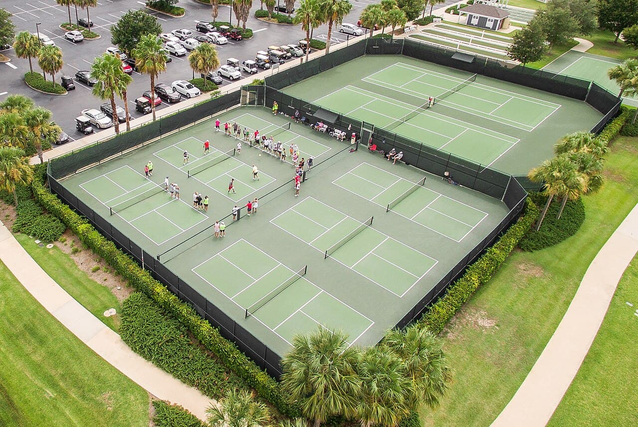 Aerial view of a block of outdoor pickleball courts with doubles games under way